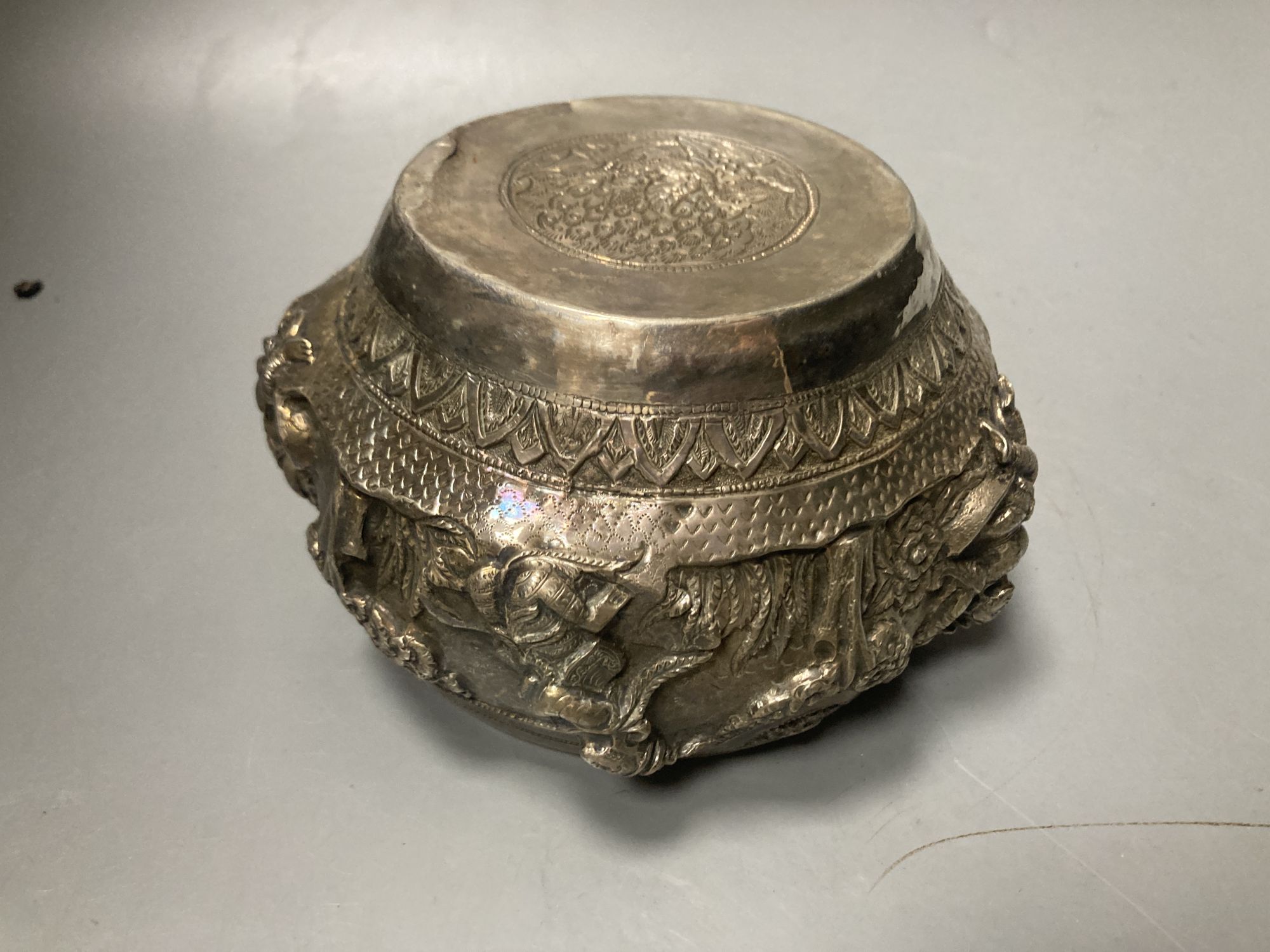 A small Burmese white metal bowl, embossed with deities, repaired, width 15.5c m, gross 10 oz.